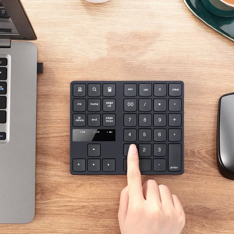 Black wireless numeric keyboard with 35 keys on a desk