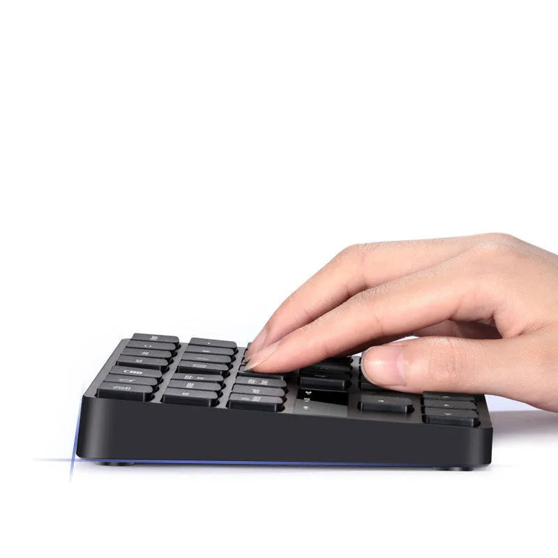 Black wireless numeric keyboard with 35 keys on a desk