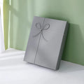 Empty rectangular gift box in blue, white and grey, made from thick cardboard with a special paper outer layer and optional bow or handbag.