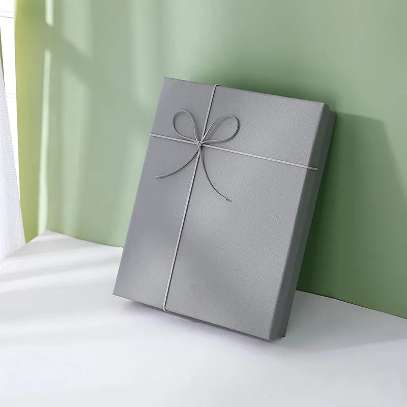 Empty rectangular gift box in blue, white and grey, made from thick cardboard with a special paper outer layer and optional bow or handbag.