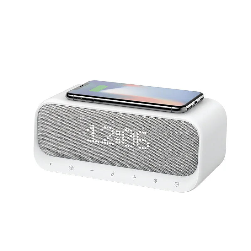 White Anker Soundcore Bluetooth speaker with wireless charging dock and digital alarm clock display.