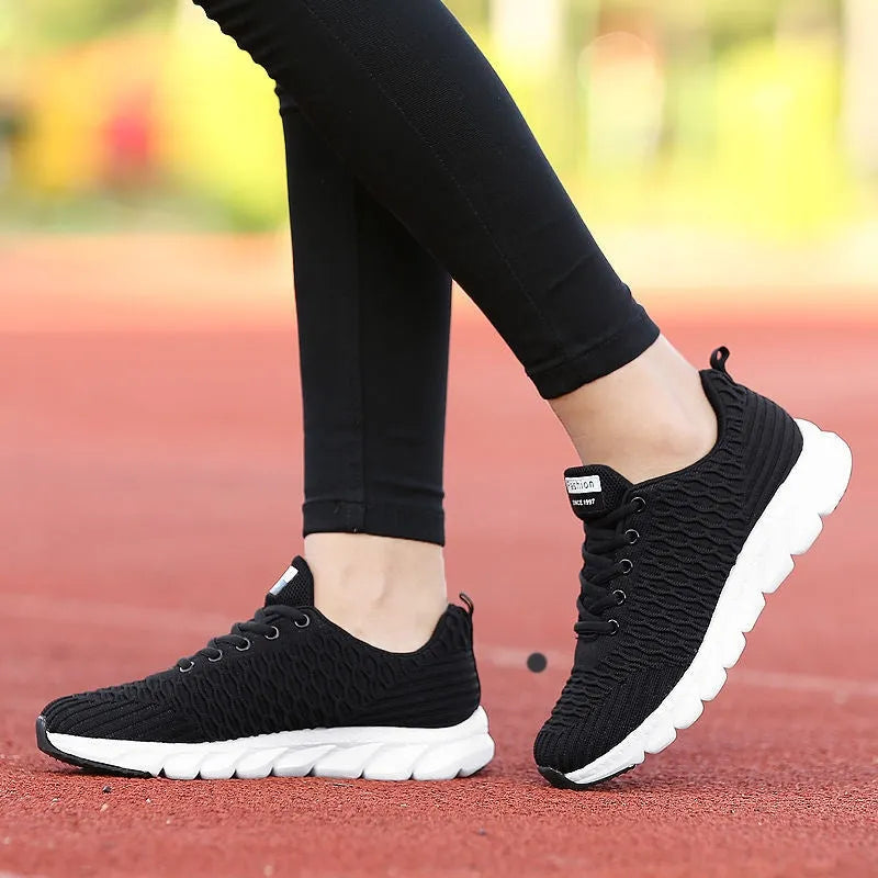 Women's running shoes in black, pink, or white with fly weave upper and wear-resistant sole