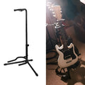 Black foldable metal guitar stand with rubber pads, holding an acoustic guitar.
