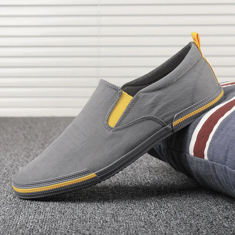 Men's low-top casual canvas shoes in grey, black orange, or khaki with vulcanised rubber soles.