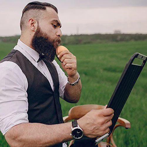 Natural boar beard brush for men in black finish with dense bristles on a table
