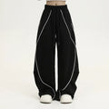 Black and grey striped men's wide-leg pleated sports pants on a hanger.