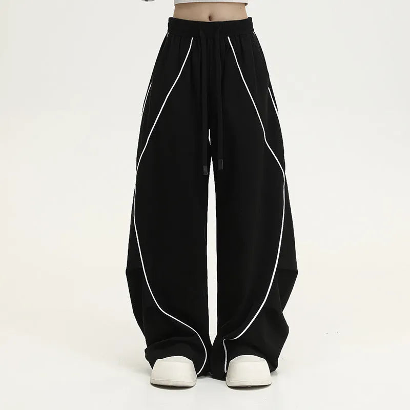 Black and grey striped men's wide-leg pleated sports pants on a hanger.