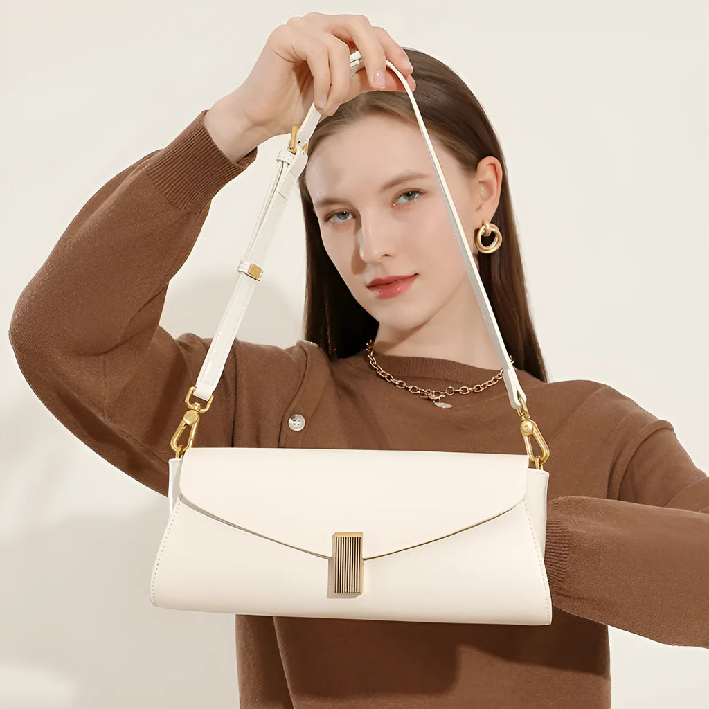 Milky white cowhide leather women's cross-body bag with pillow shape and cross-body strap.