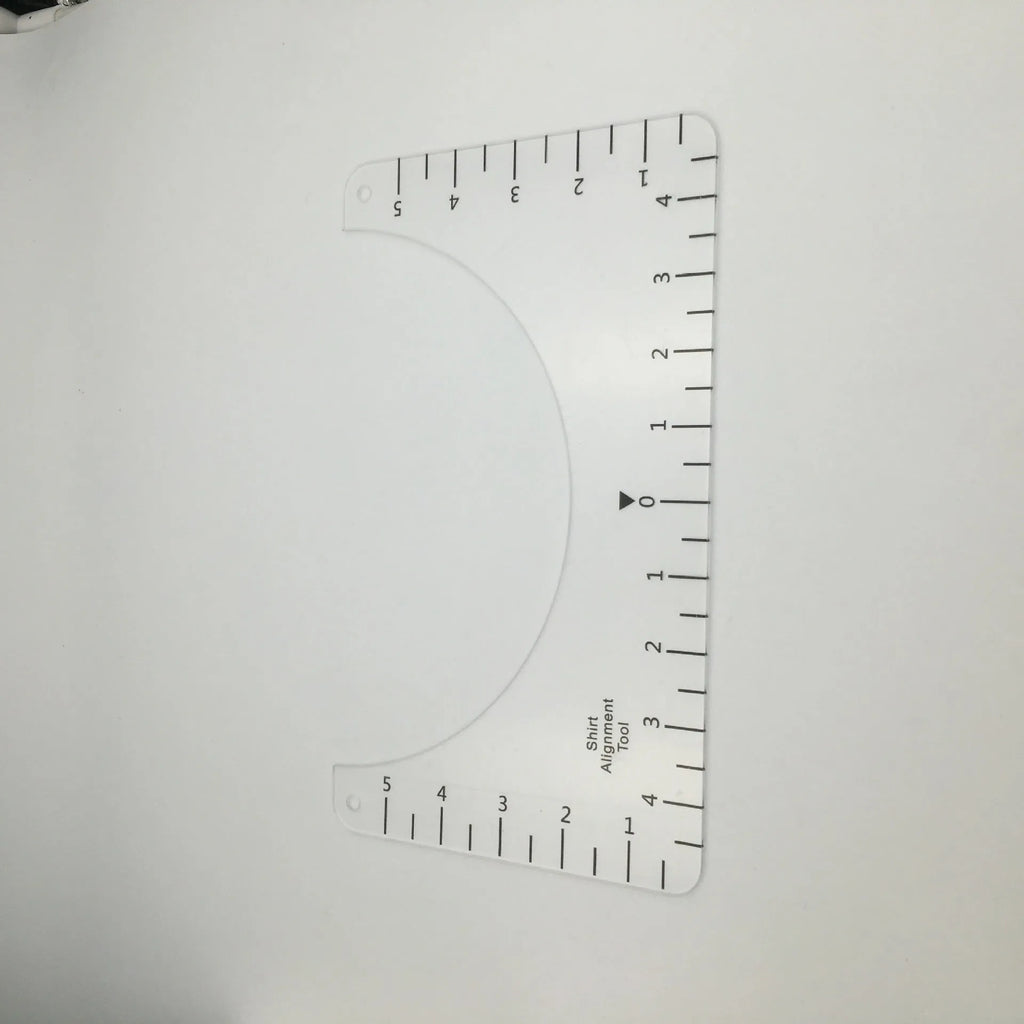 Transparent acrylic sewing ruler for aligning T-shirt designs, measuring 10 by 6 inches.