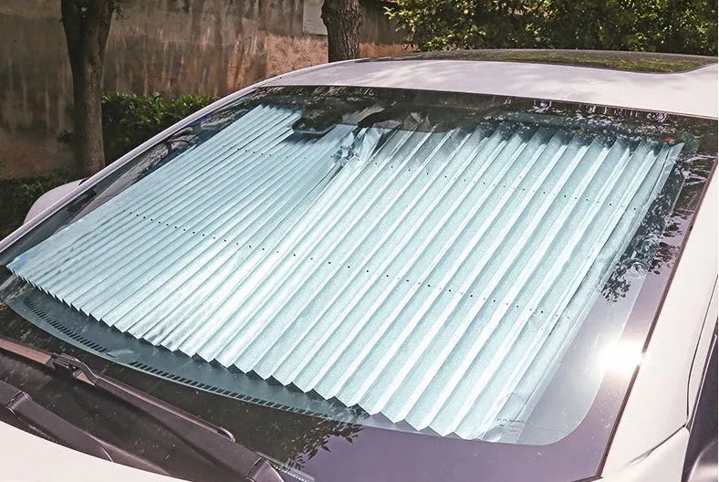 Car sun visor of aluminised film measuring 46cm sliding into position on a car windscreen