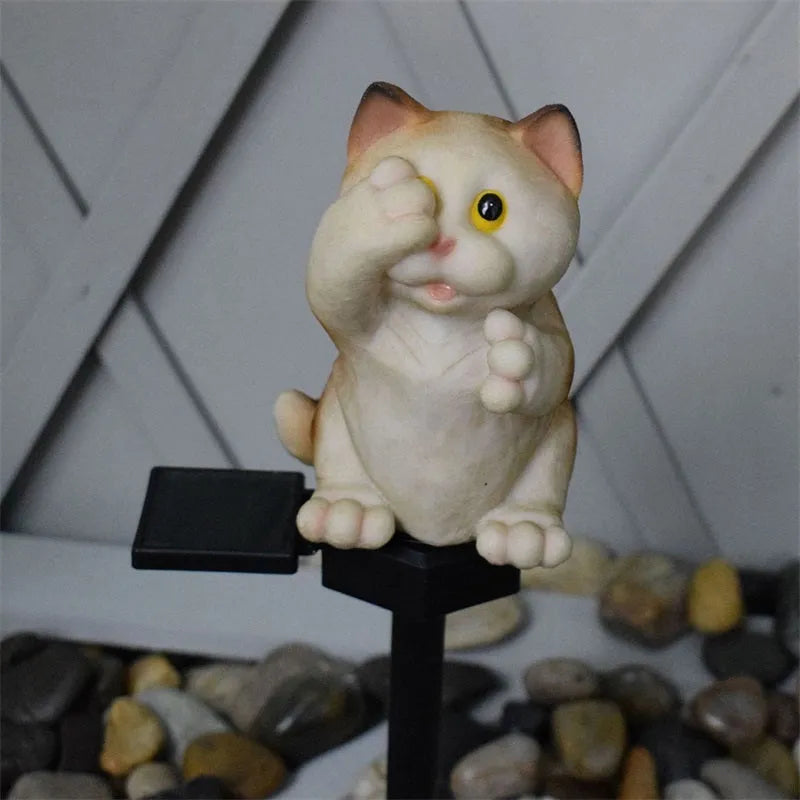 Brown cat-shaped solar lawn light in garden setting with LED illumination at dusk