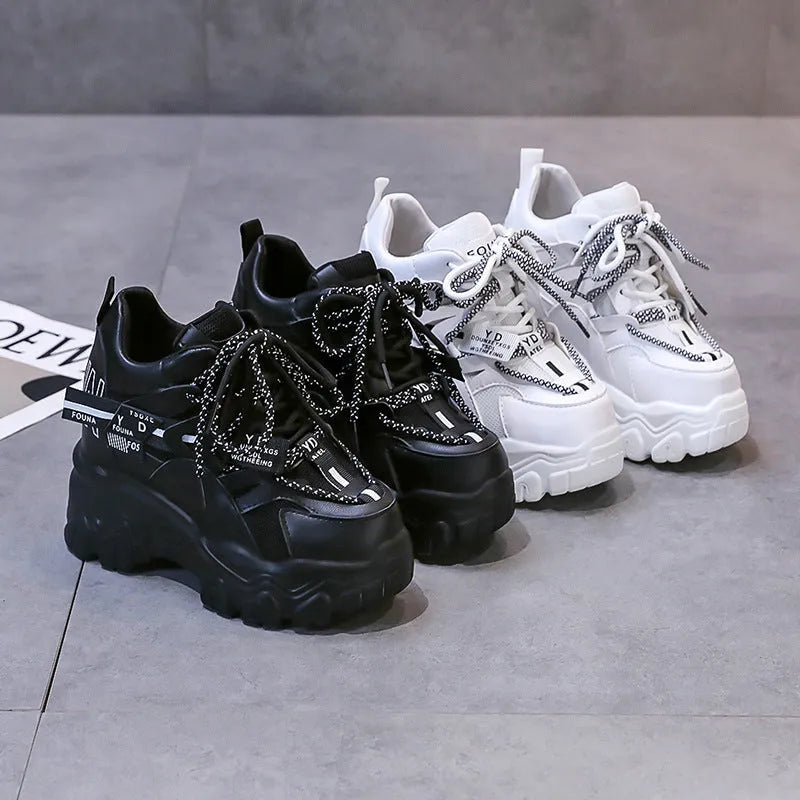 Women's white and black mesh platform sports shoes with cross strap and rubber sole.