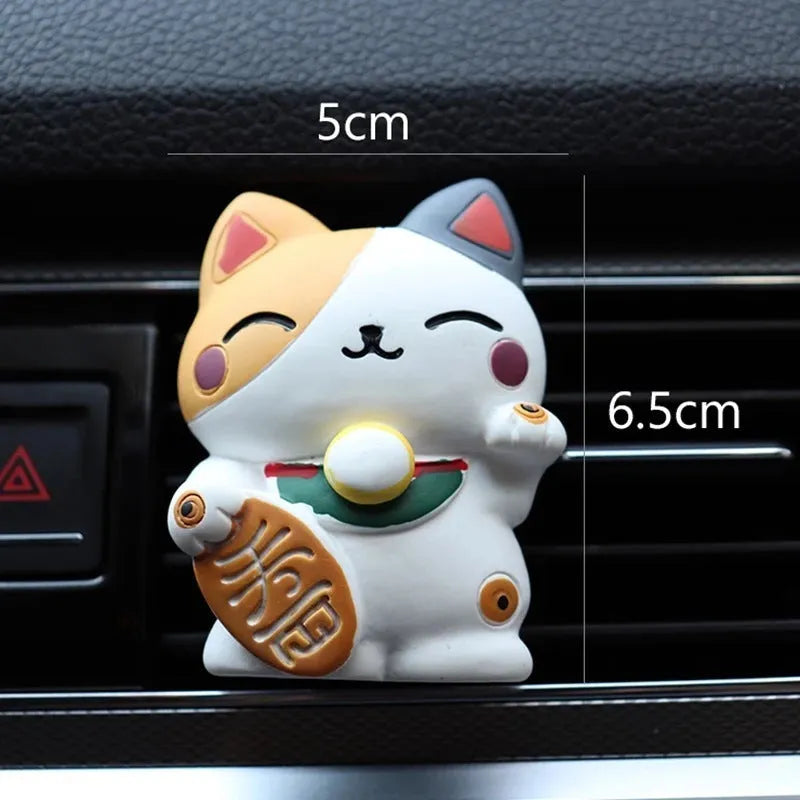 Black and white cat resin aromatherapy clip attached to a car air conditioning vent.