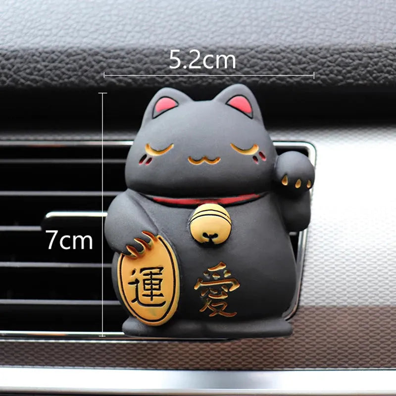 Black and white cat resin aromatherapy clip attached to a car air conditioning vent.