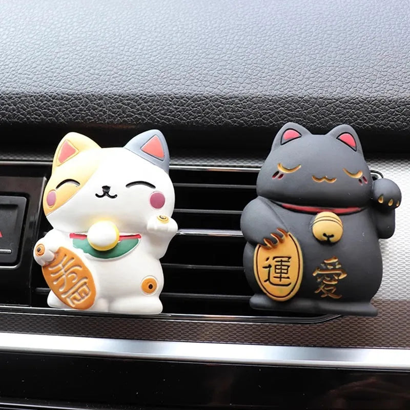 Black and white cat resin aromatherapy clip attached to a car air conditioning vent.