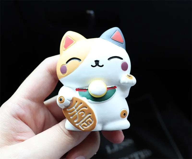 Black and white cat resin aromatherapy clip attached to a car air conditioning vent.