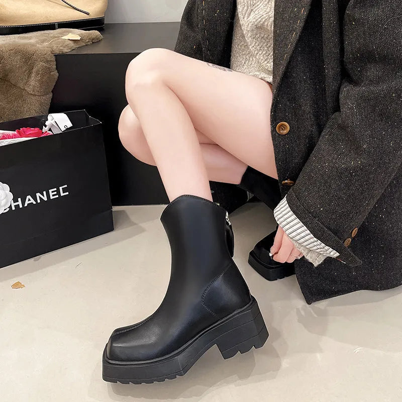 Black women's platform ankle boots with a square toe, chunky sole, and a back zip fastener.