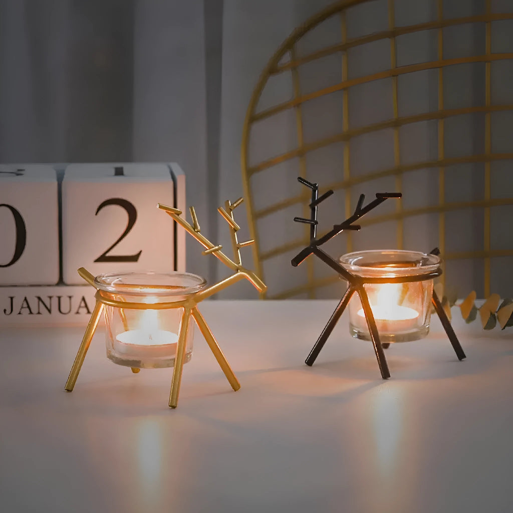 Wrought iron fawn candle holder in gold finish with glass cup on a table