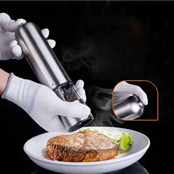 Stainless steel electric pepper grinder on a kitchen countertop.