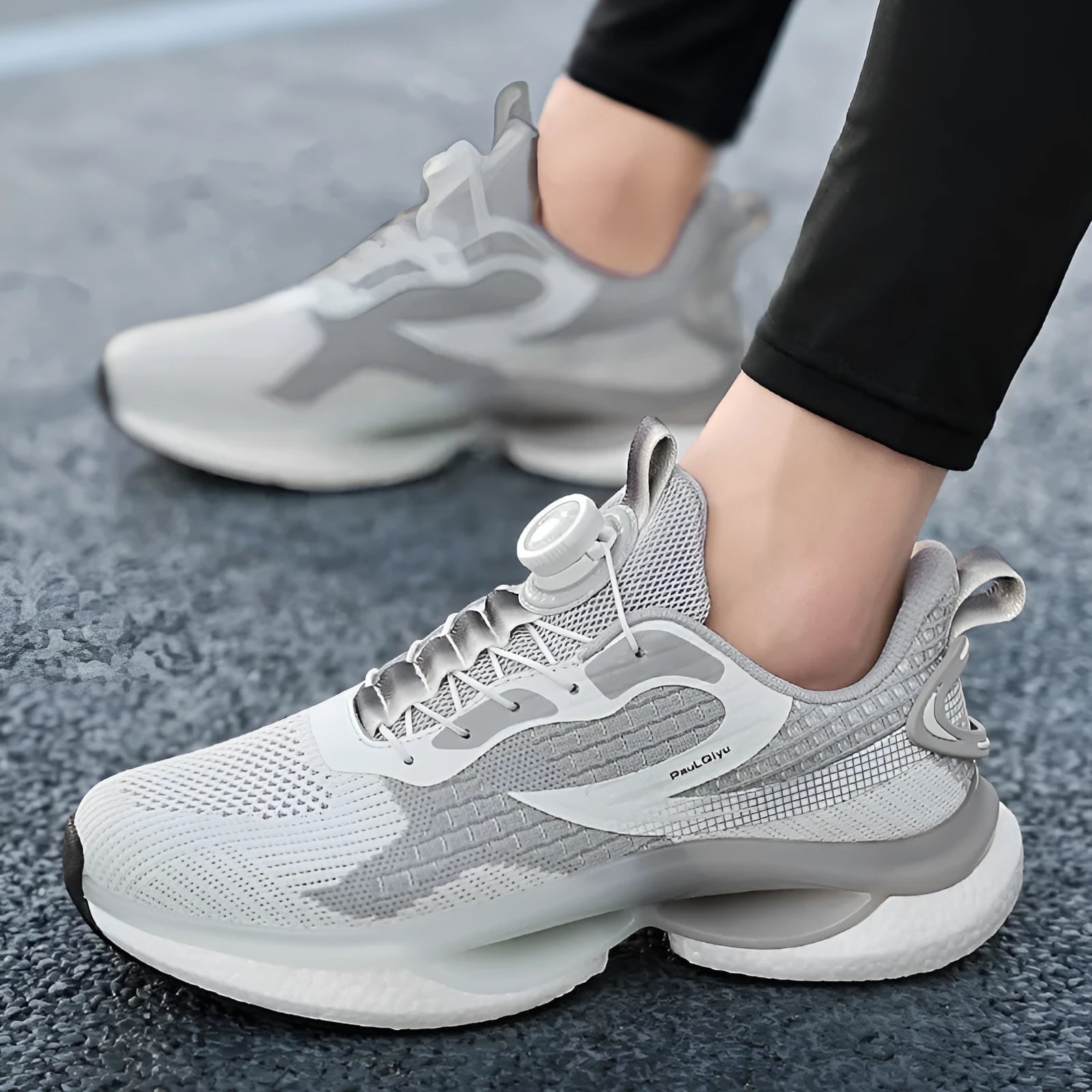 Men's white rotating button running shoes with mesh upper and buckle closure on a solid background.