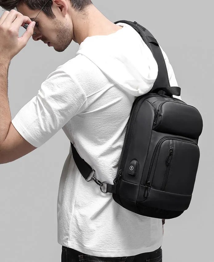 Black PVC medium-sized shoulder bag with air cushion strap and soft handle.