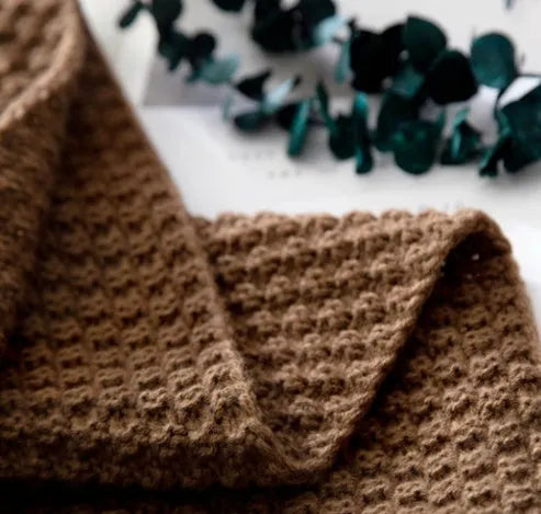 Nordic-style fringed knit ball acrylic blanket in beige colour, laid flat showing its 130x170cm size.