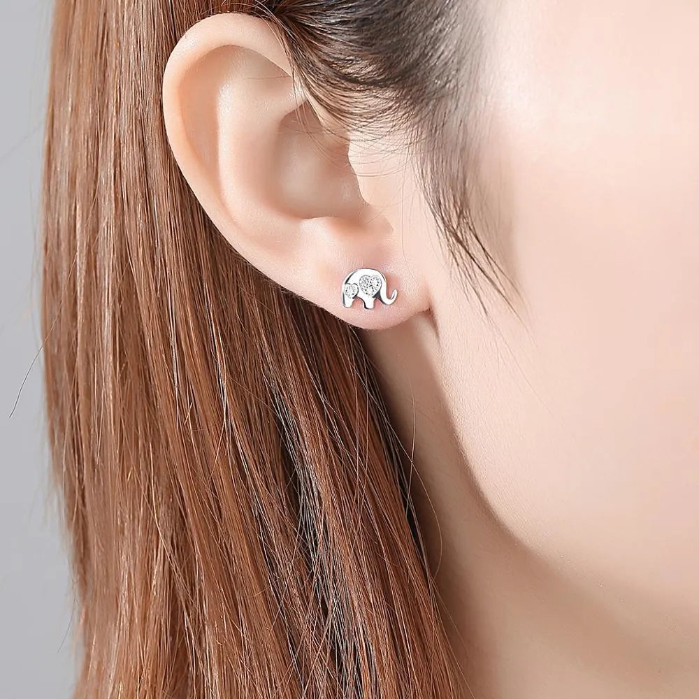 Geometric shaped silver earrings with gem setting, shown in gold and silvery finishes.