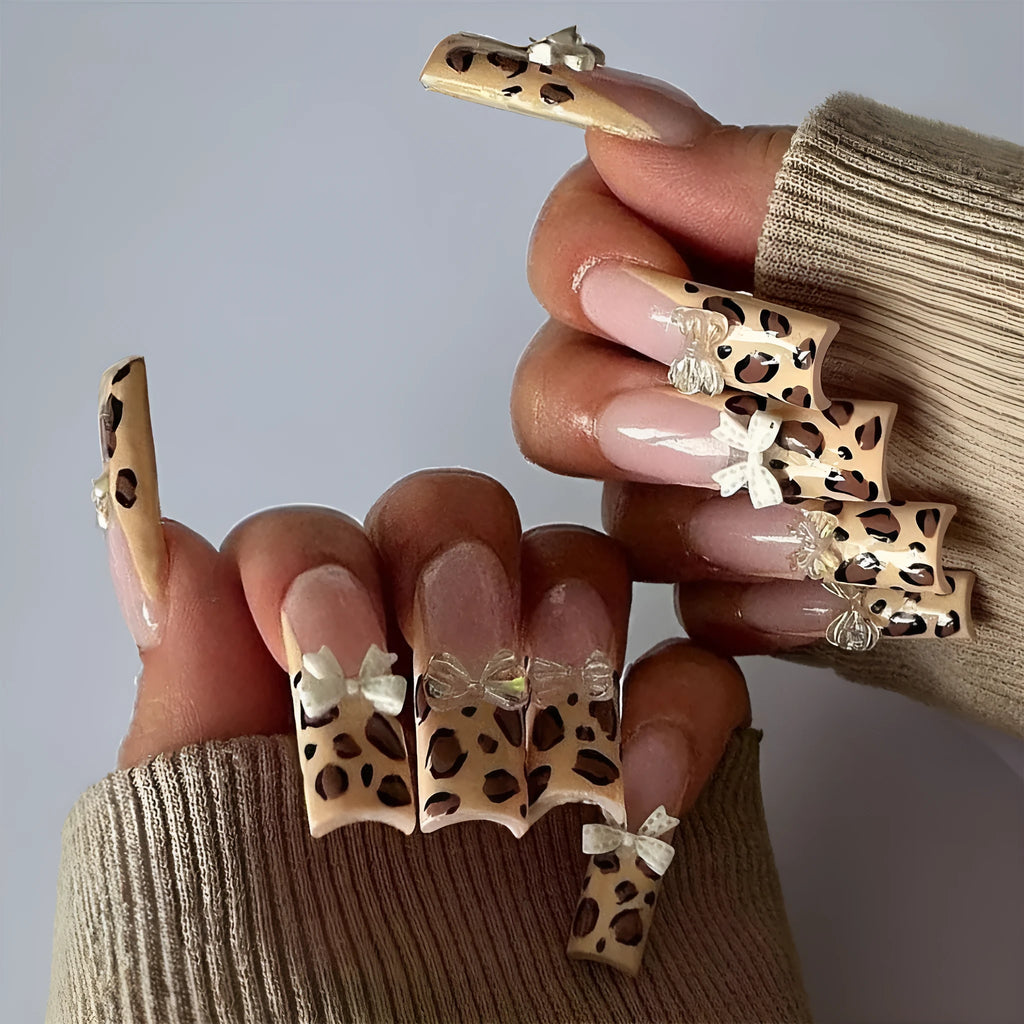 Leopard print butterfly shaped nail art decals on a plastic sheet.
