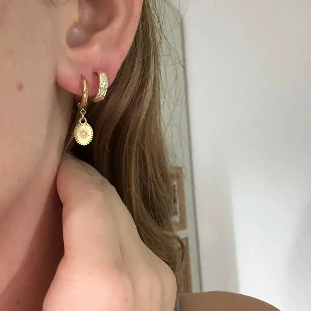 A pair of geometric stainless steel ear button earrings with an ellipse detail, shown in colour XY-EH005.