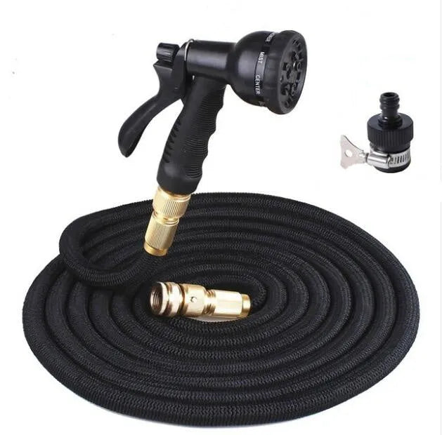 Expandable magic flexible water hose in black laid on grass showing compact initial length and stretched working length