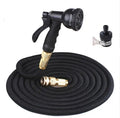 Expandable magic flexible water hose in black laid on grass showing compact initial length and stretched working length