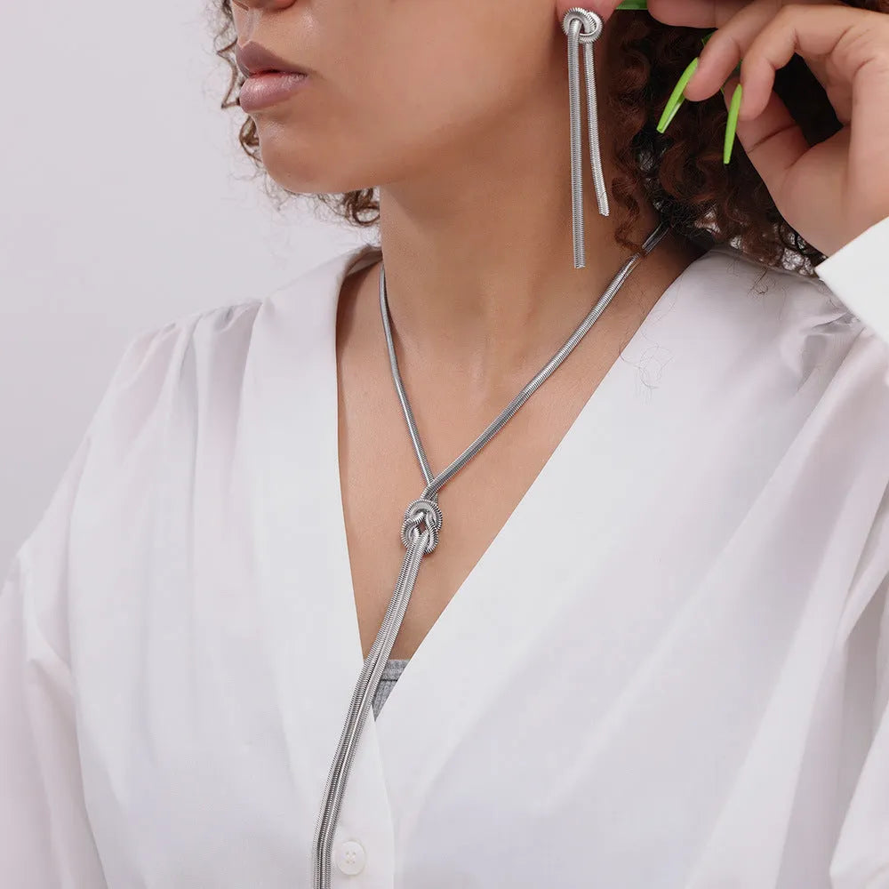 Gold knotted tassel pendant on long snake chain necklace with matching titanium steel earrings