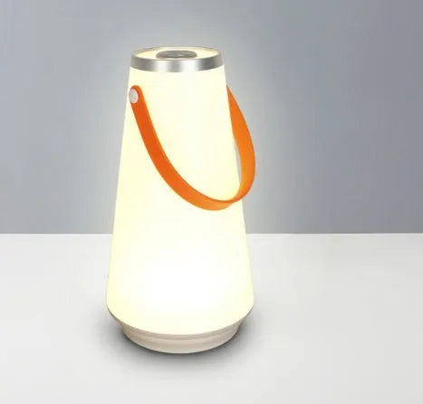 White rechargeable LED table lamp with USB cable on a wooden surface.