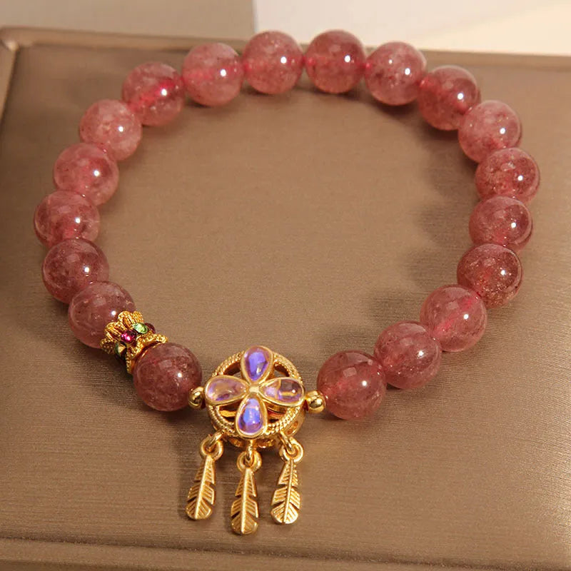 Natural strawberry quartz bracelet for women with a four-leaf dream catcher ball pendant on an elastic cord.