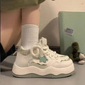 Women's green patent leather platform sneaker with lace-up front and round toe design on rubber sole
