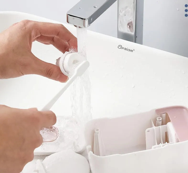 Automatic toothpaste dispenser wall mounted unit in blue, grey or pink colours with no-drip nozzle