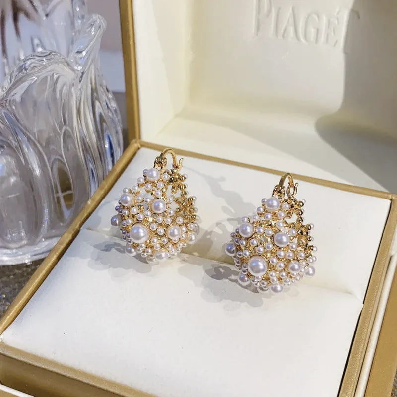 Women's gold copper earrings with floral basket design featuring small beads and pearl inlay detailing