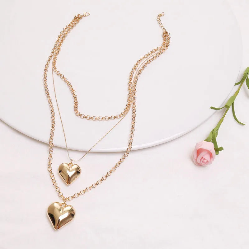 Gold multi-layer heart pendant necklace for women with alloy construction and electroplated finish.