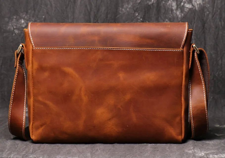 Brown vintage leather men's messenger bag with a shoulder strap showing internal organiser pockets.