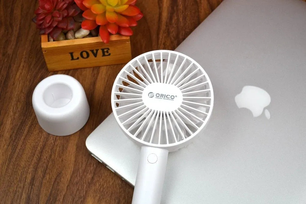 White ORICO FH1 USB rechargeable desk fan with fine-line texture on a desk, showing compact size.