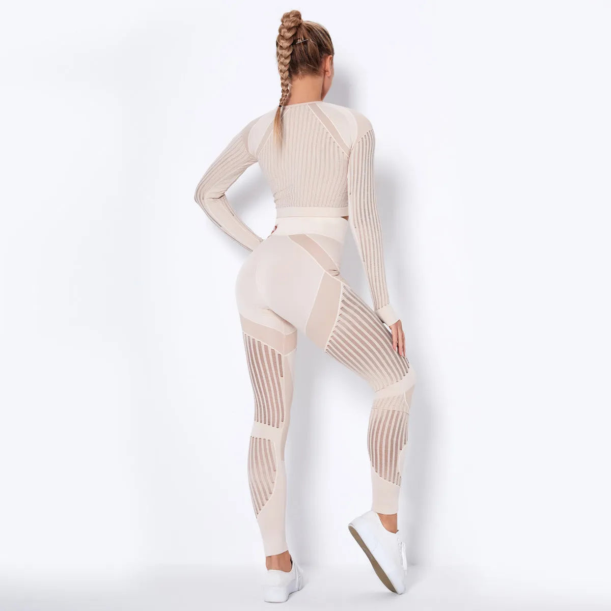 Woman wearing a seamless long-sleeved yoga suit in a neutral colour, demonstrating a stretch pose.
