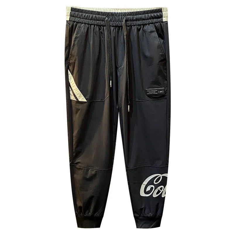 Black men's casual cotton trousers with cropped legs and an ankle band on a solid background.