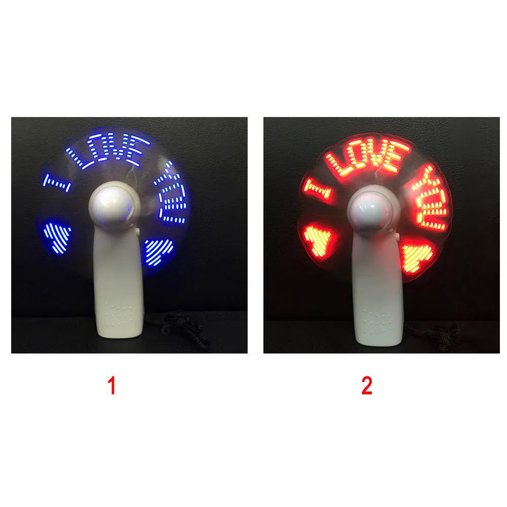 White handheld mini fan with blue and red LED love pattern display, shown next to AAA batteries for scale.