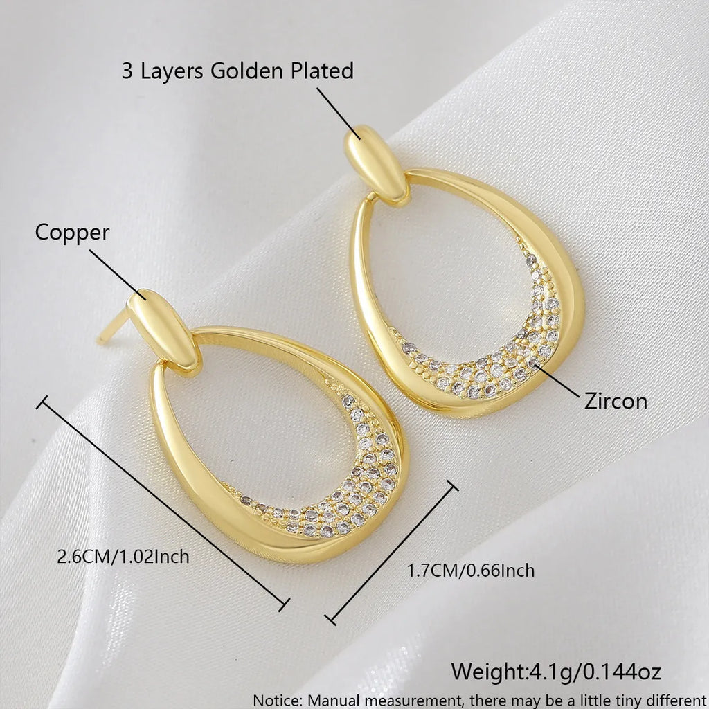 Women's yellow gold geometric drop earrings with ring and oval elements measuring 2.6 by 1.7 cm