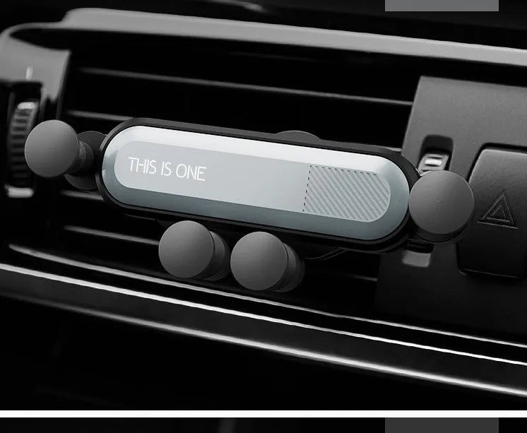 Universal car air vent phone holder with adjustable grip in black colour mounted in vehicle