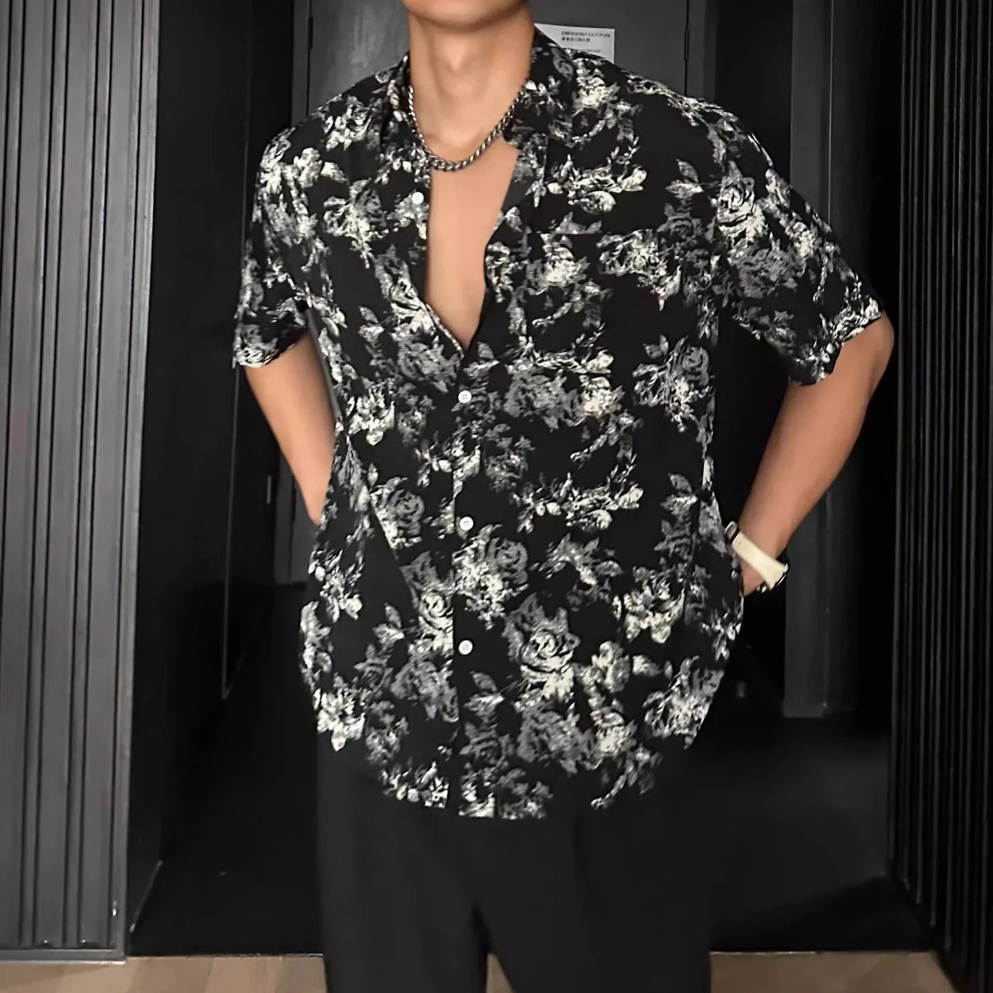 Loose fitting floral printed short sleeve shirt in black on a hanger