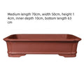 Handmade rectangular purple clay flower pot in a garden setting showing its size and ceramic texture.