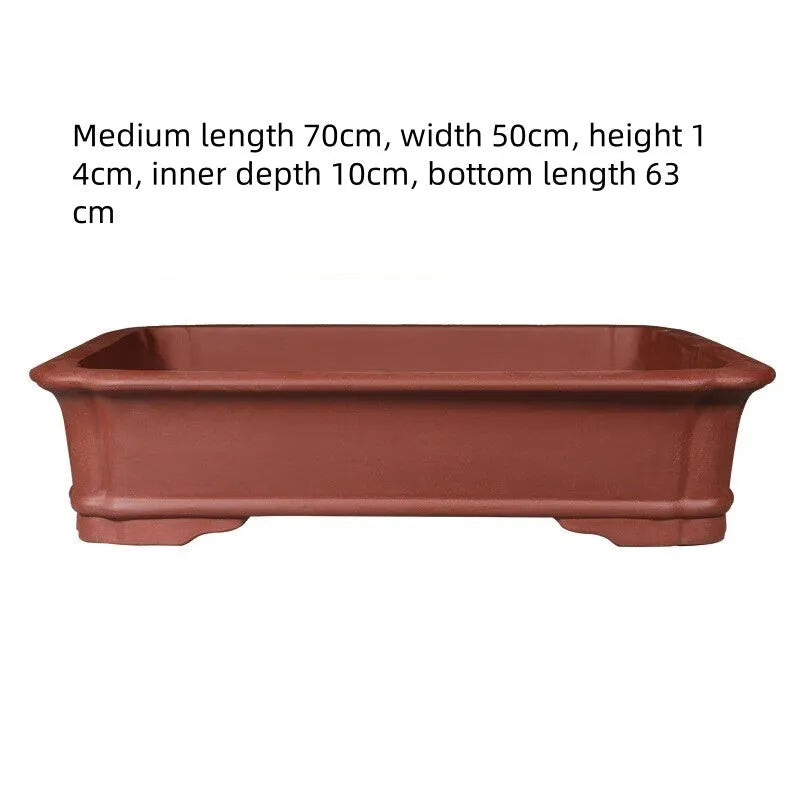 Handmade rectangular purple clay flower pot in a garden setting showing its size and ceramic texture.