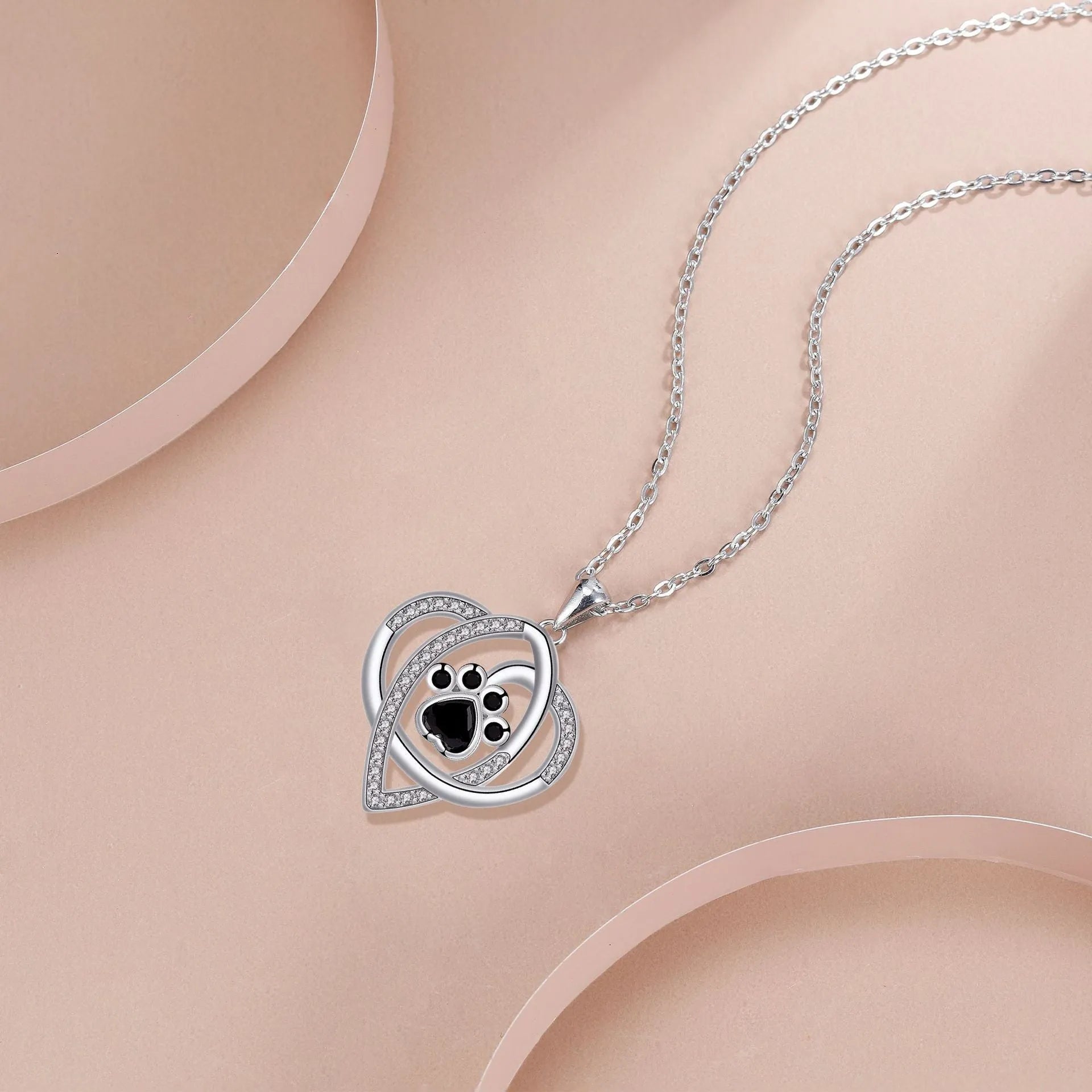 Women's copper necklace with dog and cat paw print pendant on cross chain.