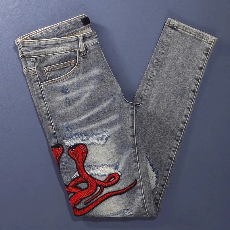Men's slim fit distressed jeans with embroidered patches in old colour wash